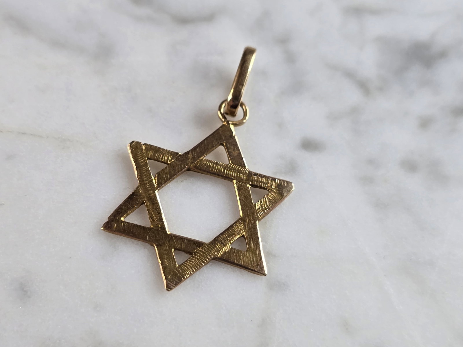 Vintage Estate 14K Yellow Gold Jewish Judaica Star of David Pendant: A VINTAGE ESTATE 14K YELLOW GOLD JUDAICA STAR OF DAVID PENDANT. THE PENDANT WEIGHS 1.8g AND MEASURES 1 1/4" LONG BY 3/4" WIDE. PENDANT IS NOT MARKED, BUT IT HAS BEEN TESTED. DOES SHOW SOME SIGNS OF WE