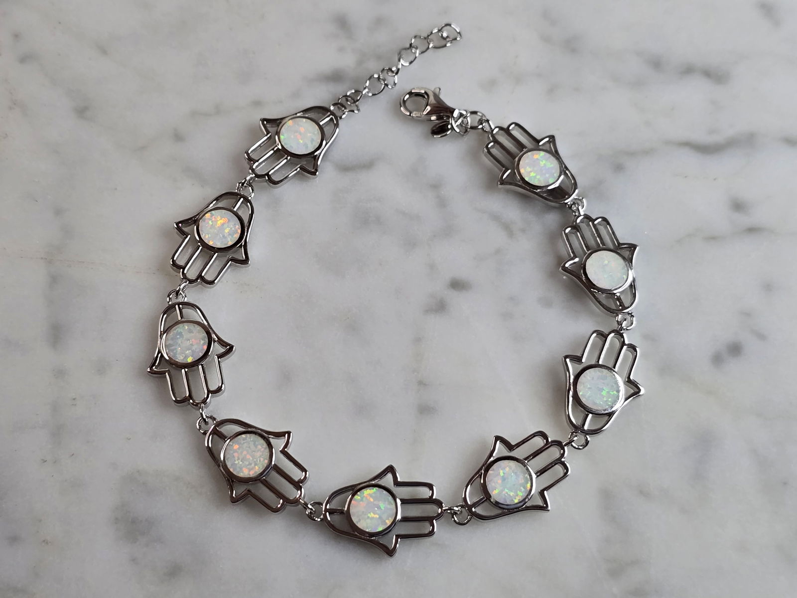 Womens Sterling Silver Opal Judaica Hamsa Hand Bracelet: A WOMENS STERLING SILVER OPAL COLORED JUDAICA HAMSA HAND BRACELET. THE BRACELET WEIGHS 10.3g, AND MEASURES 8" LONG BY 1/2" WIDE. NOT SURE IF OPAL IS NATURAL OR MAN MADE. ANY QUESTIONS PLEASE DO NOT HE
