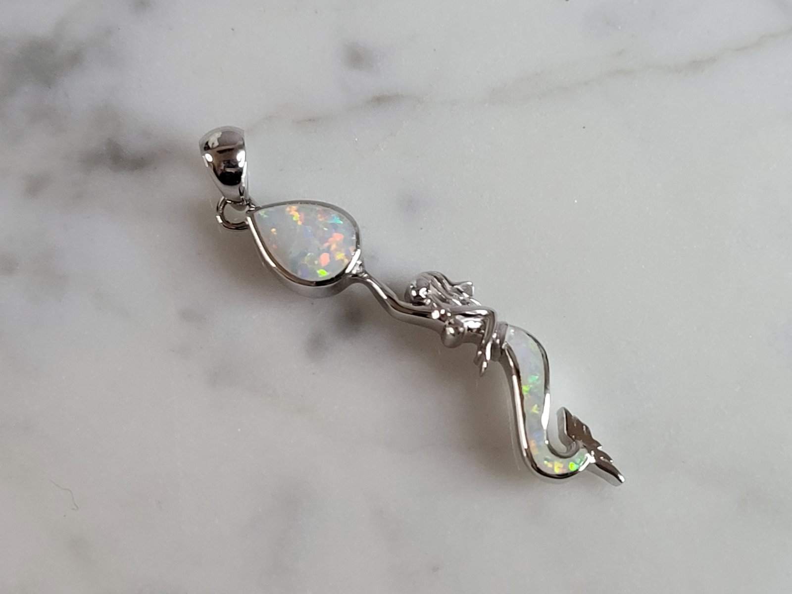 Womens Estate Sterling Silver Modernist Opal Mermaid Pendant: WOMENS ESTATE STERLING SILVER MODERNIST OPAL COLORED MERMAID PENDANT THAT WEIGHES 2.9g, AND MEASURES 1 1/2" LONG BY 1/4" WIDE. NOT SURE IF STONES ARE REAL OR MAN MADE. ANY QUESTIONS, PLEASE DO NOT HES