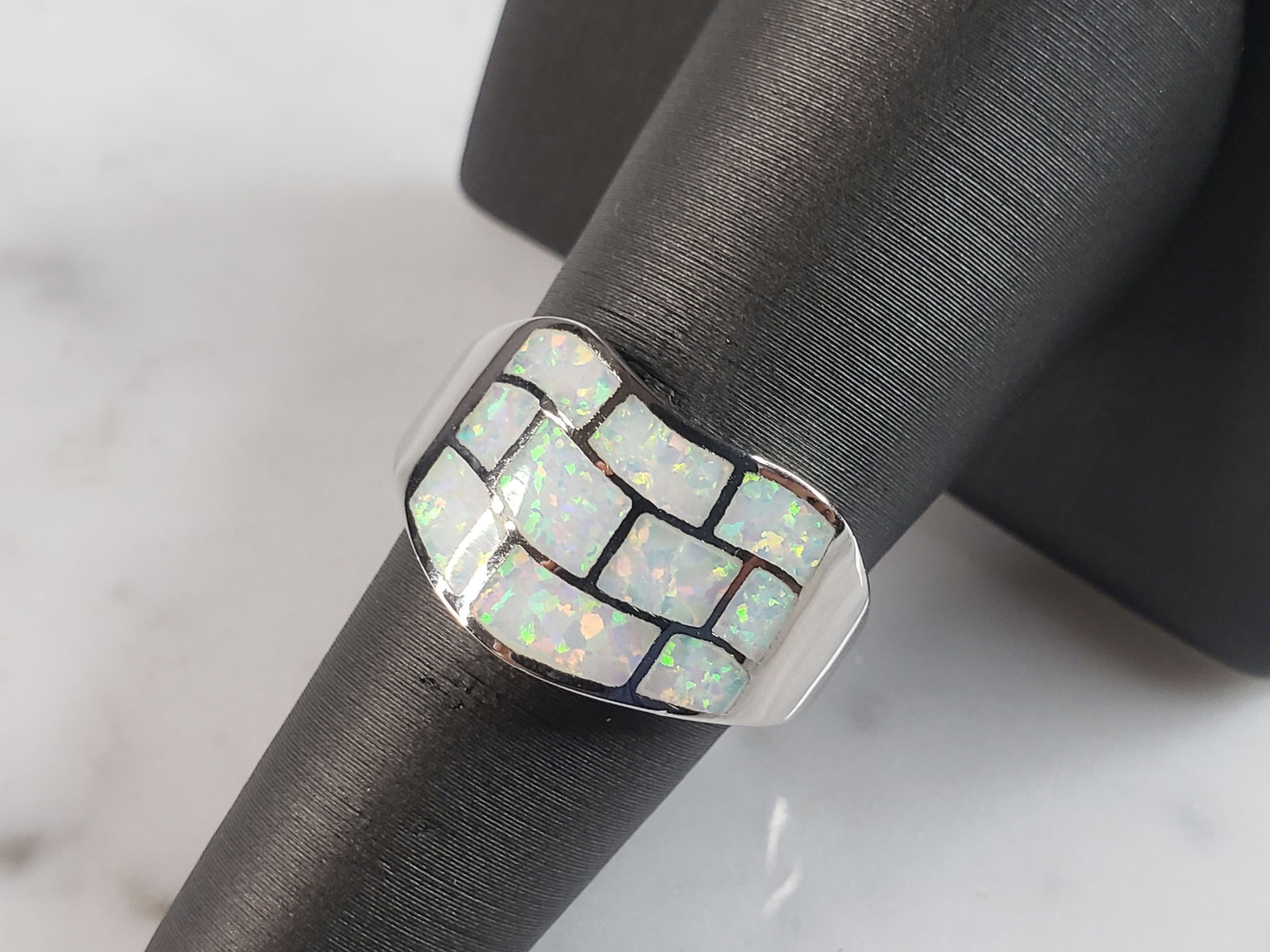Womens Estate Sterling Silver Modernist Opal Ring: A WOMENS ESTATE STERLING SILVER MODERNIST OPAL COLORED RING. THE RING IS A SIZE 5.75, AND WEIGHS 4.3g. WIDTH OF RING MEASURES 1/2". NOT SURE IF STONE IS NATURAL OR MAN MADE. THE RING MAKES A BEAUTIFUL