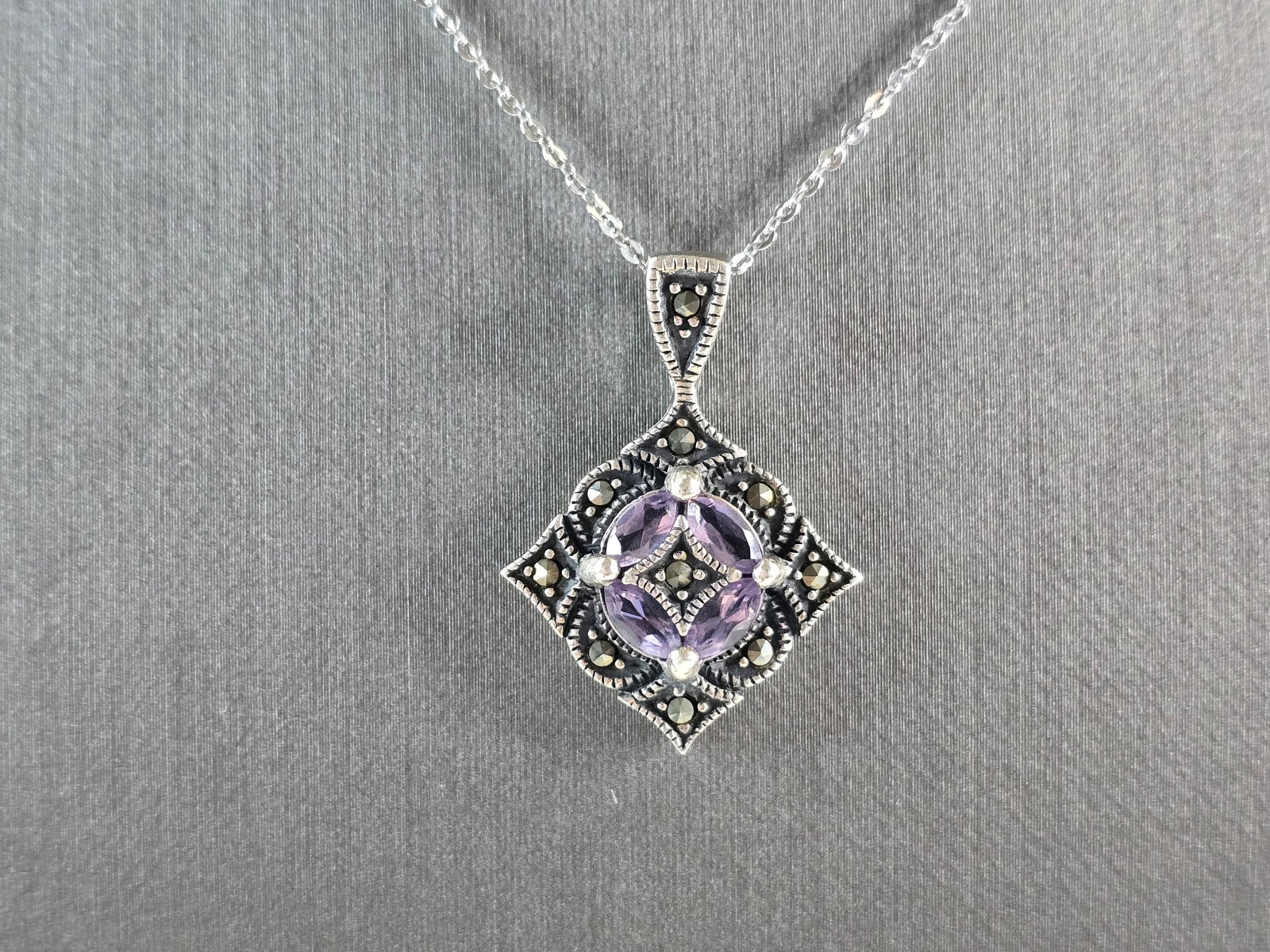 Womens Estate Sterling Silver Art Deco Amethyst Pendant Necklace: A WOMENS VINTAGE ESTATE STERLING SILVER ART DECO STYLE PENDANT WITH NECKLACE . THE PENDANT ITSELF MEASURES 1 1/8" LONG BY 7/8" WIDE. NECKLACE IS 18" LONG. TOTAL WEIGHT IS 5.8g. NOT SURE IF STONES ARE 