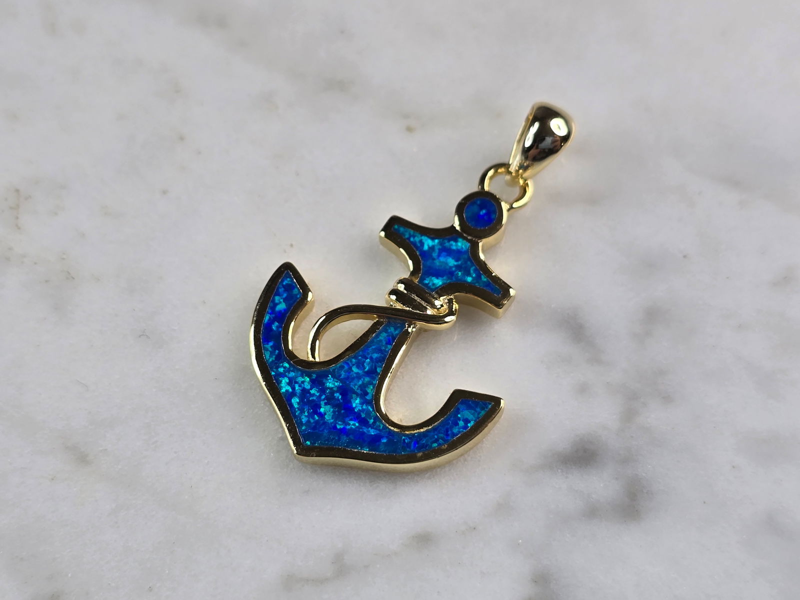 Womens Sterling Silver Gold Tone Blue Opal Anchor Pendant: A WOMENS STERLING SILVER GOLD TONE BLUE OPAL ANCHOR PENDANT. THE PENDANT WEIGHS 3.0g AND MEASURES 1 1/4" LONG BY 3/4" WIDE. NOT SURE IF STONES ARE NATURAL OR MAN MADE. MAKES A GREAT GIFT FOR THAT SOME