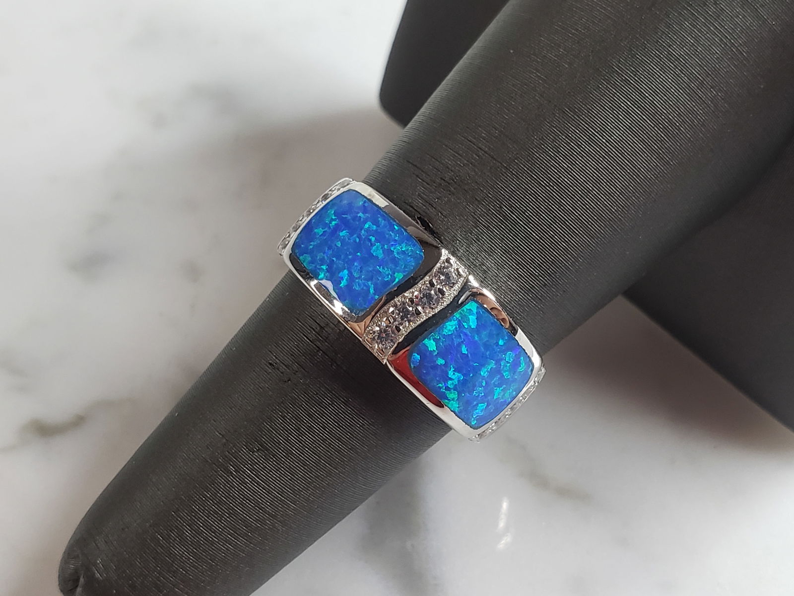 Womens Estate Sterling Silver Modernist Blue Opal Ring: A WOMENS ESTATE STERLING SILVER MODERNIST BLUE OPAL COLORED RING. THE RING IS A SIZE 7.0 AND WEIGHS 5.0g. WIDTH OF RING MEASURES 3/8". NOT SURE IF STONE IS NATURAL OR MAN MADE. THE RING MAKES A BEAUTI