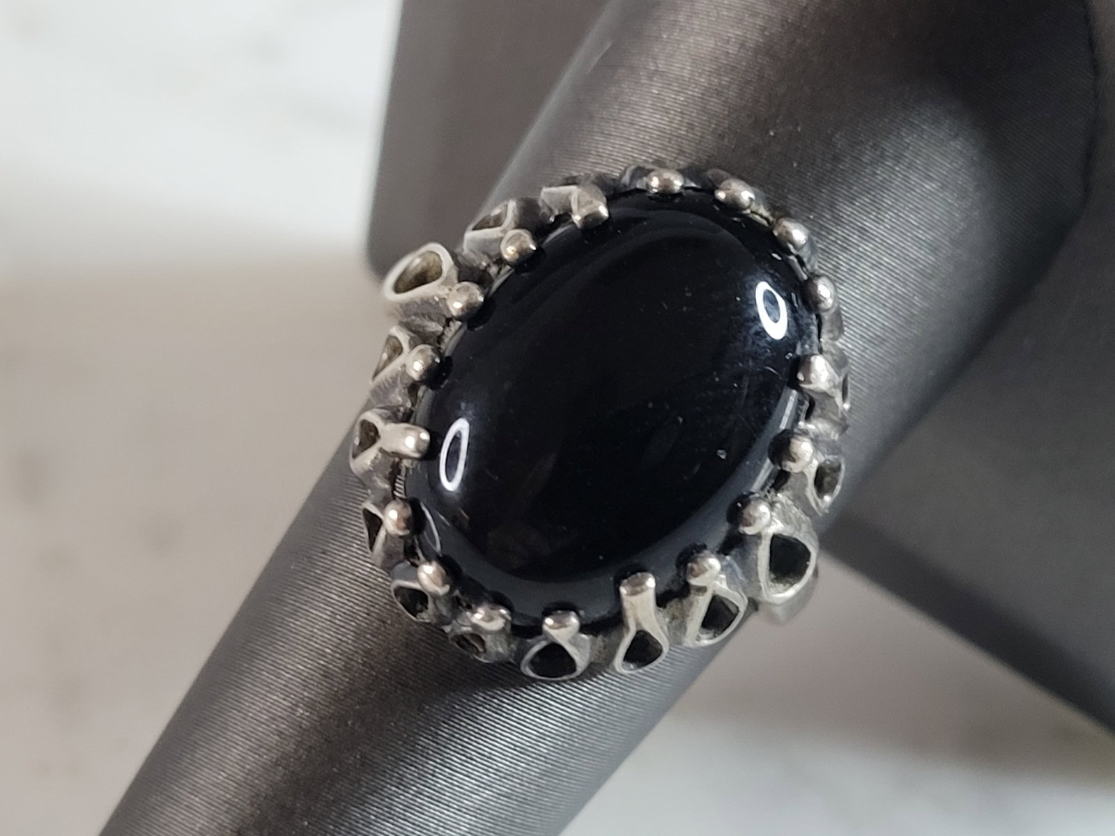 Womens Vintage Estate Sterling Silver Onyx Kabana Ring: A WOMENS VINTAGE ESTATE STERLING SILVER ONYX RING THAT WAS MADE BY KABANA. NOT SURE IF STONE IS NATURAL OR MAN MADE. THE RING WEIGHS 5.8g, AND IS A SIZE 9.25. THE WIDTH OF THE RING IS 7/8". ANY QUESTI