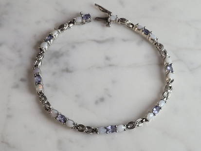 Womens Vintage Estate 10K Gold Opal Tanzanite Tennis Bracelet: A WOMENS VINTAGE ESTATE 10K WHITE GOLD OPAL & TANZANITE TENNIS BRACELET. THE BRACELET MEASURES 7 1/4" LONG BY 1/8" WIDE, AND WEIGHS 7.7g. NOT SURE IF THE STONES ARE REAL OR MAN MADE. WOULD MAKE A GREA