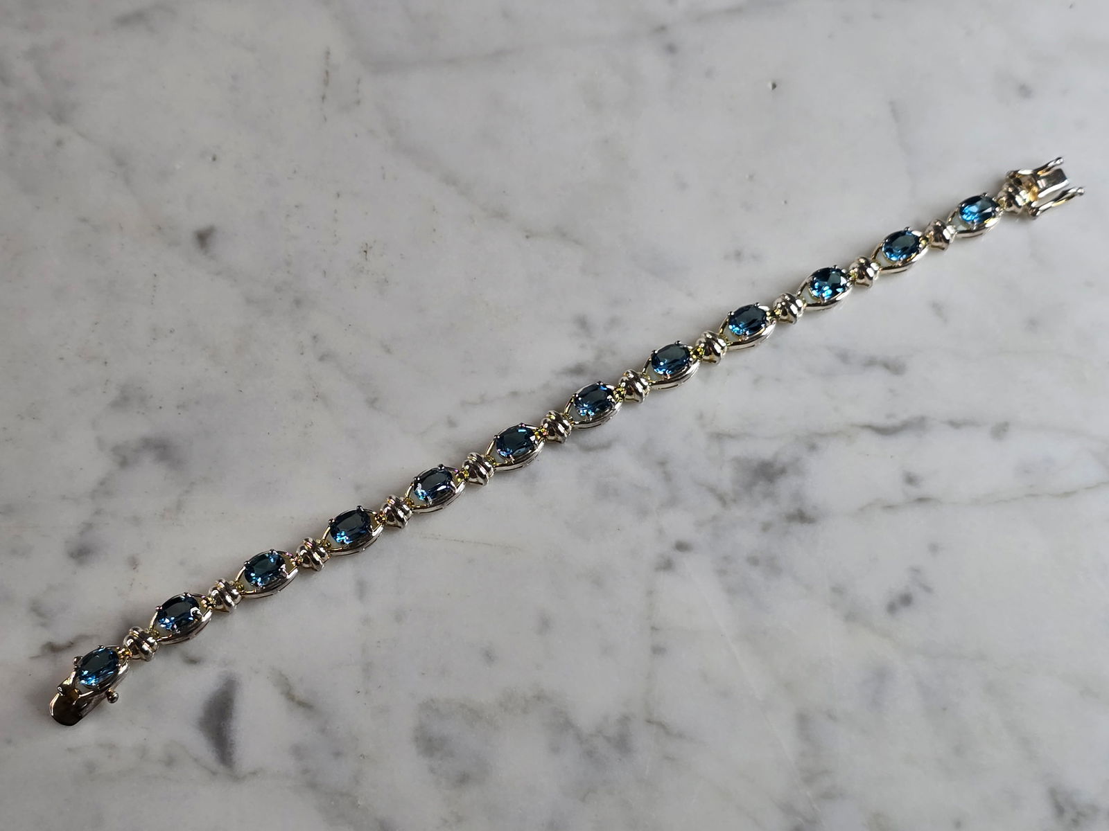 Womens Vintage Estate Sterling Silver Topaz Bracelet: A WOMENS VINTAGE ESTATE STERLING SILVER TOPAZ COLORED BRACELET. BRACELET MEASURES 7 1/2" LONG BY 1/4" WIDE, AND WEIGHS 16.4g. NOT SURE IF STONES ARE NATURAL OR MAN MADE. WOULD MAKE A LOVELY GIFT FOR T