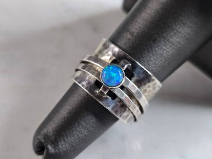 Womens Vintage Estate Sterling Silver Hammered Modernist Opal Ring: A WOMENS VINTAGE ESTATE STERLING SILVER HAMMERED MODERNIST RING WITH AN OPAL COLORED STONE. THE RING SIZE IS A 6.5, AND WEIGHS 7.9g. THE WIDTH OF THE RING IS 1/2". NOT SURE IF THE STONE IS NATURAL OR
