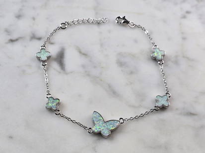 Womens Sterling Silver Opal Butterfly Charm Bracelet: A WOMENS STERLING SILVER MODERNIST OPAL COLORED BUTTERFLY CHARM BRACELET. THE BRACELET WEIGHS 5.3g AND MEASURES 8 1/2" LONG BY 1/2". NOT SURE IF OPAL IS NATURAL OR MAN MADE. ANY QUESTIONS PLEASE DO NO