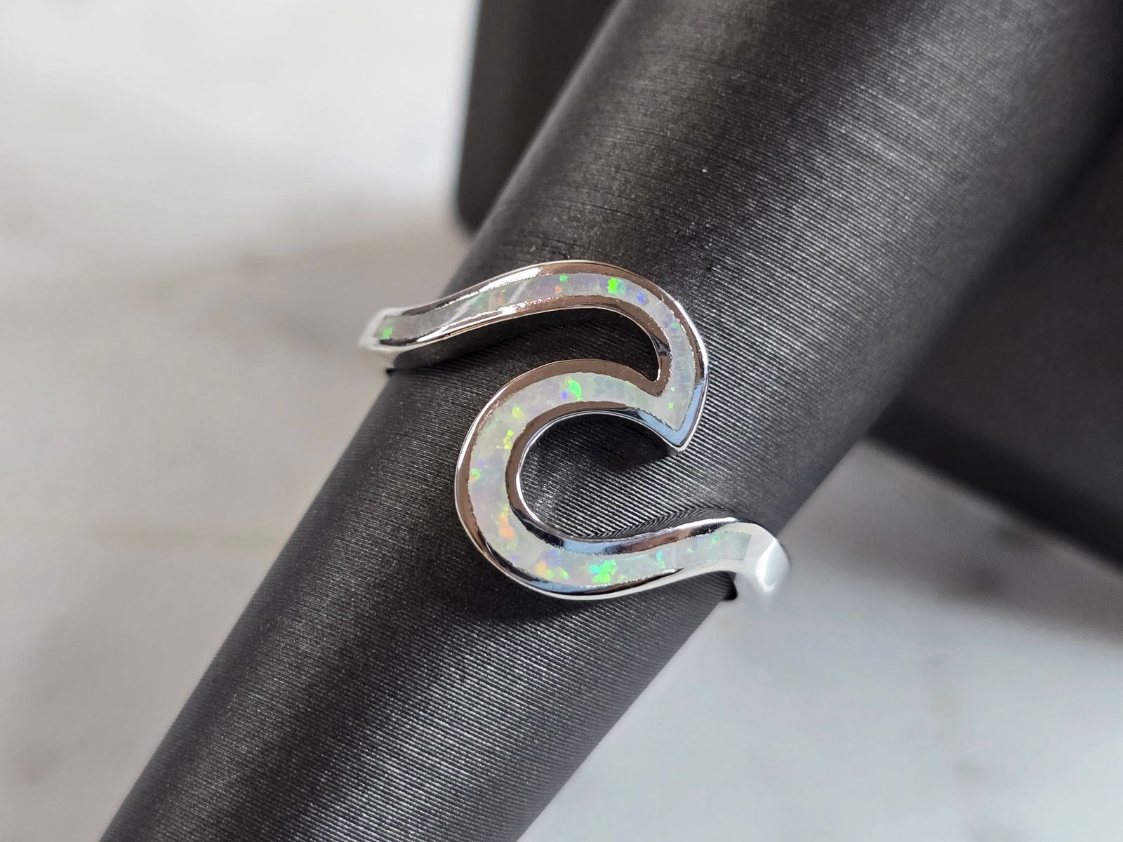 Womens Estate Sterling Silver Modernist Opal Wave Ring: A WOMENS ESTATE STERLING SILVER MODERNIST OPAL COLORED WAVE RING. THE RING IS A SIZE 7.0 AND WEIGHS 2.5g. WIDTH OF RING MEASURES 1/2". NOT SURE IF STONE IS NATURAL OR MAN MADE. THE RING MAKES A BEAUTI