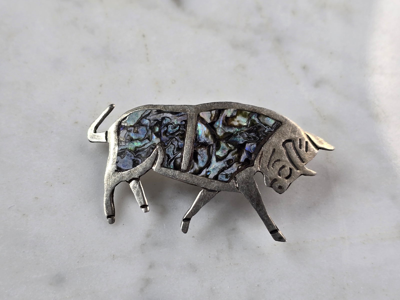 Womens Vintage Estate MOP Abalone Sterling Silver Bull Brooch Pin: A WOMENS VINTAGE ESTATE MOTHER OF PEARL OR ABALONE STERLING SILVER BULL BROOCH. THE TOTAL WEIGHT OF THE BROOCH IS 2.8g. THE BROOCH MEASURES 1 1/2" LONG BY 7/8" WIDE. MAKES A GREAT GIFT FOR THAT SPECIA