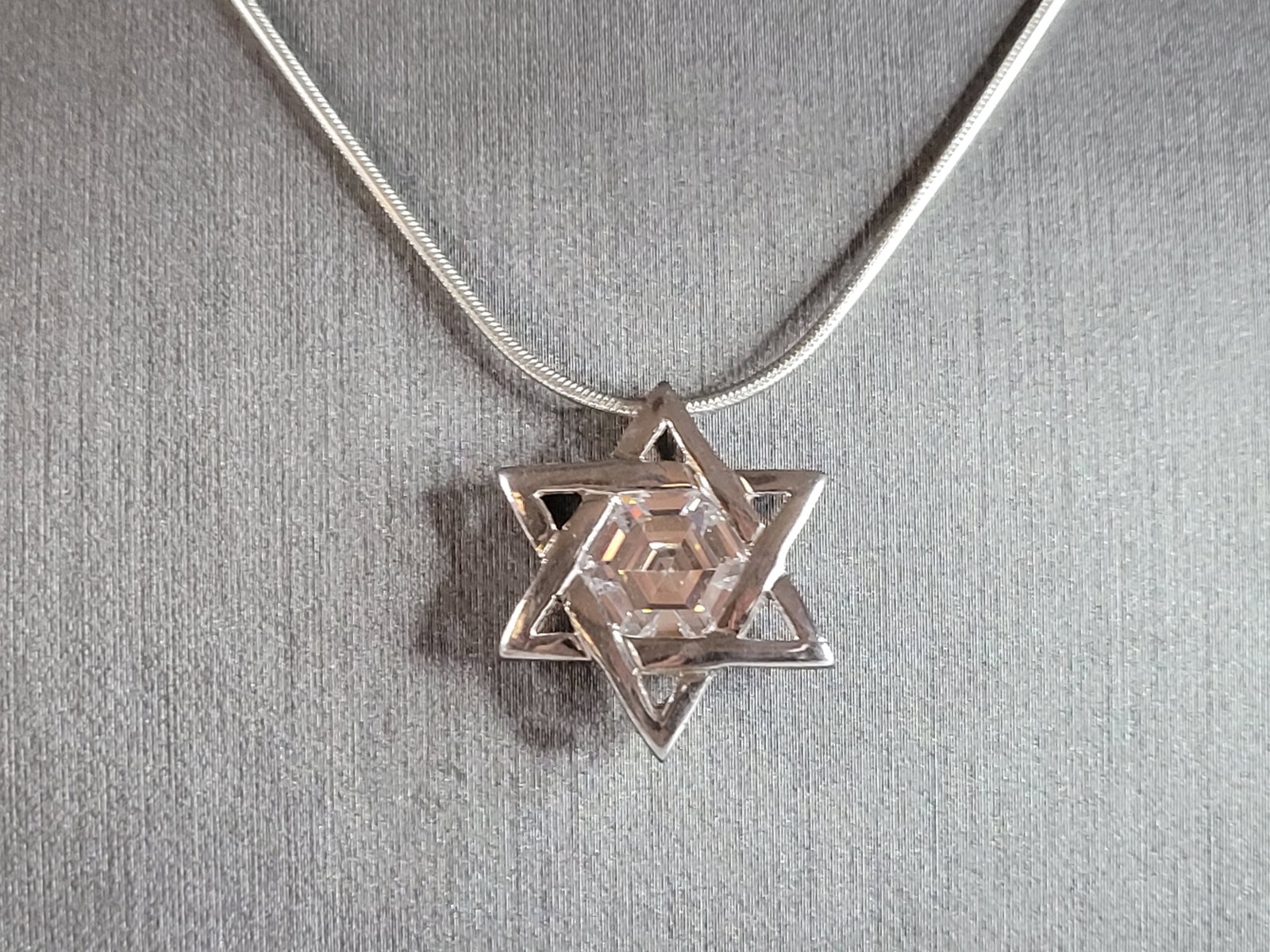 Vintage Estate Sterling Silver Jewish Judaica Star of David Pendant Necklace: A VINTAGE ESTATE STERLING SILVER MODERNIST STAR OF DAVID PENDANT WITH NECKLACE. THE PENDANT AND NECKLACE WEIGH 8.5g. THE NECKLACE MEASURES 20", AND THE PENDANT MEASURES 1" LONG BY 3/4" WIDE. MAKES A G