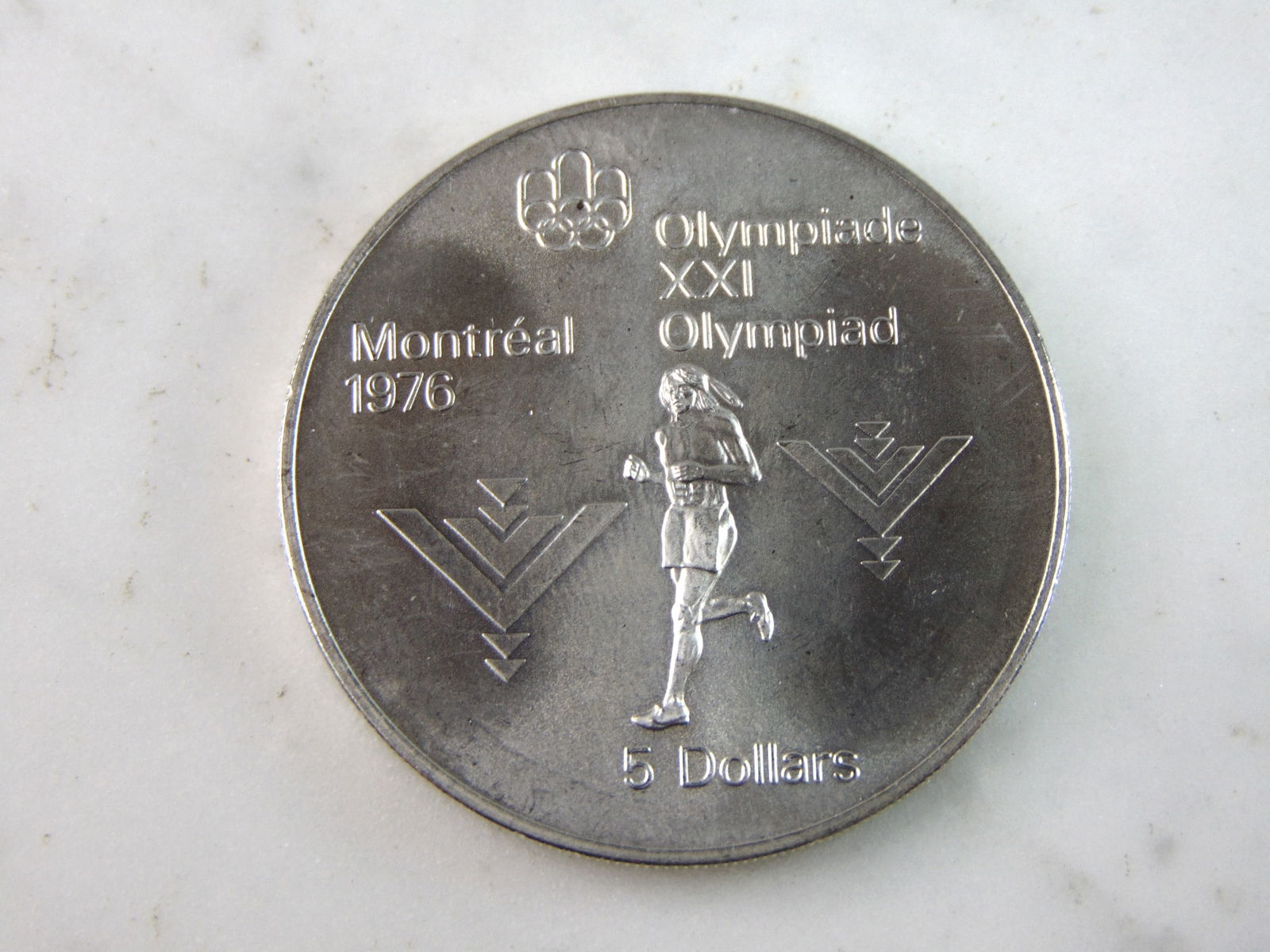 1975 $5 Canadian '76 Montreal Summer Olympics Silver Coin: FOR SALE IS THIS 1975 $5 CANADIAN '76 MONTREAL SUMMER OLYMPICS SILVER COIN. COIN WEIGHS 24.3g. COIN APPEARS TO BE IN VERY GOOD CONDITION, UNC , HOWEVER WE ARE NOT COIN EXPERTS WHEN IT COMES TO