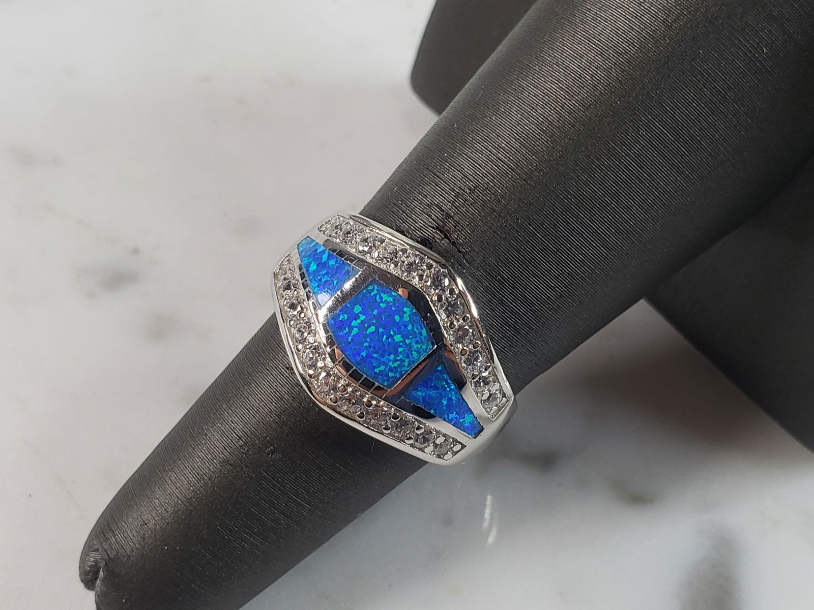 Womens Estate Sterling Silver Modernist Blue Opal & CZ Ring: A WOMENS ESTATE STERLING SILVER MODERNIST BLUE OPAL COLORED RING. THE RING IS A SIZE 6.0 AND WEIGHS 5.7g. WIDTH OF RING MEASURES 1/2". NOT SURE IF STONE IS NATURAL OR MAN MADE. THE RING MAKES A BEAUTI