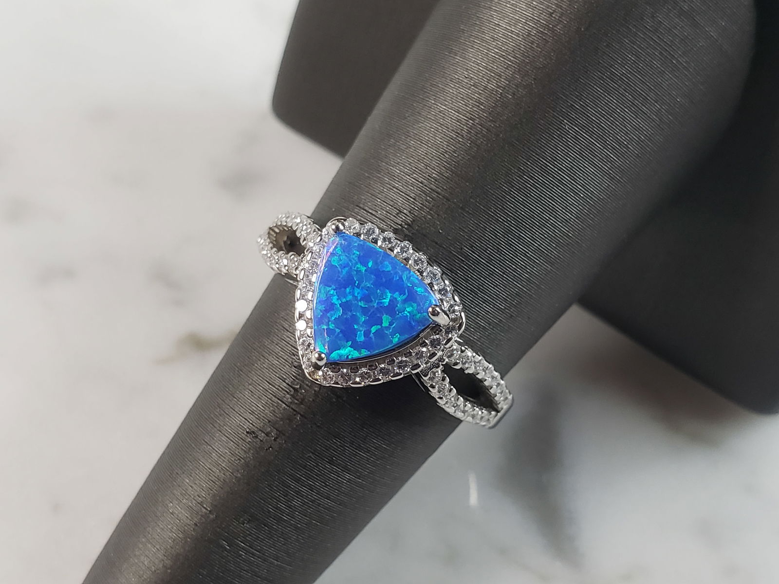 Womens Estate Sterling Silver Modernist Blue Opal & CZ Ring: A WOMENS ESTATE STERLING SILVER MODERNIST BLUE OPAL COLORED RING. THE RING IS A SIZE 7.25 AND WEIGHS 3.8g. WIDTH OF RING MEASURES 3/8". NOT SURE IF STONE IS NATURAL OR MAN MADE. THE RING MAKES A BEAUT