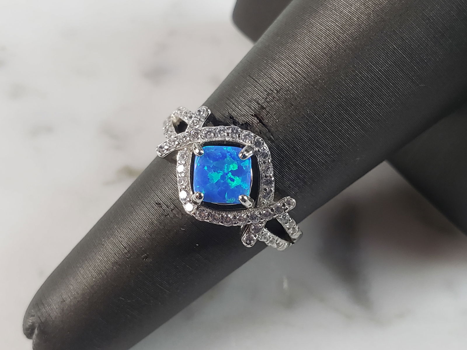 Womens Estate Sterling Silver Modernist Blue Opal & CZ Ring: A WOMENS ESTATE STERLING SILVER MODERNIST BLUE OPAL COLORED RING. THE RING IS A SIZE 6.0 AND WEIGHS 3.2g. WIDTH OF RING MEASURES 3/8". NOT SURE IF STONE IS NATURAL OR MAN MADE. THE RING MAKES A BEAUTI