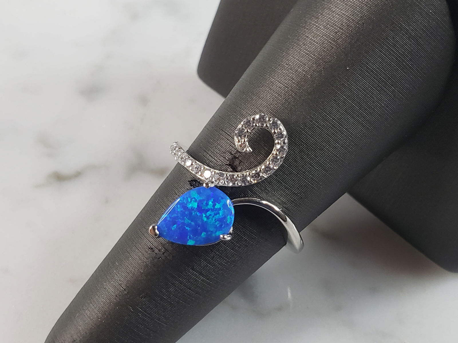 Womens Estate Sterling Silver Modernist Blue Opal & CZ Ring: A WOMENS ESTATE STERLING SILVER MODERNIST BLUE OPAL COLORED RING. THE RING IS A SIZE 7.25 AND WEIGHS 2.7g. WIDTH OF RING MEASURES 3/4". NOT SURE IF STONE IS NATURAL OR MAN MADE. THE RING MAKES A BEAUT