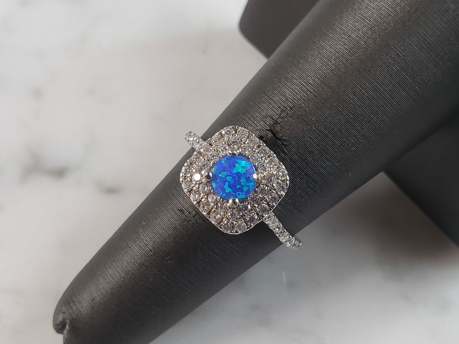 Womens Estate Sterling Silver Modernist Blue Opal & CZ Ring: A WOMENS ESTATE STERLING SILVER MODERNIST BLUE OPAL COLORED RING. THE RING IS A SIZE 6.0 AND WEIGHS 2.5g. WIDTH OF RING MEASURES 3/8". NOT SURE IF STONE IS NATURAL OR MAN MADE. THE RING MAKES A BEAUTI