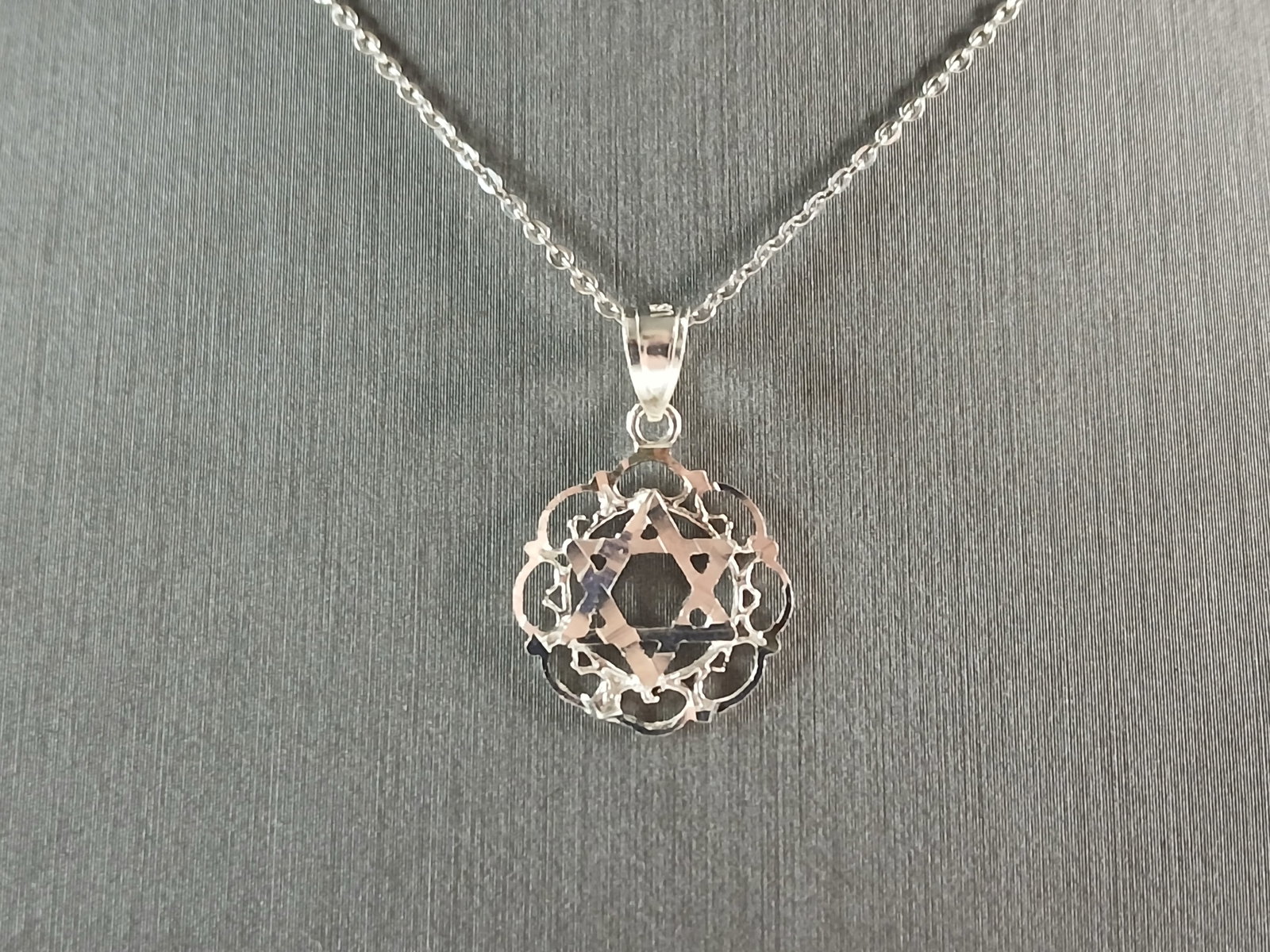 Sterling Silver Jewish Judaica Star of David Pendant Necklace: A STERLING SILVER STAR OF DAVID PENDANT WITH NECKLACE. THE PENDANT WITH NECKLACE WEIGHS 2.5g. THE NECKLACE MEASURES 18" LONG, AND THE PENDANT MEASURES 7/8" LONG BY 5/8" WIDE. MAKES A GREAT GIFT FOR TH