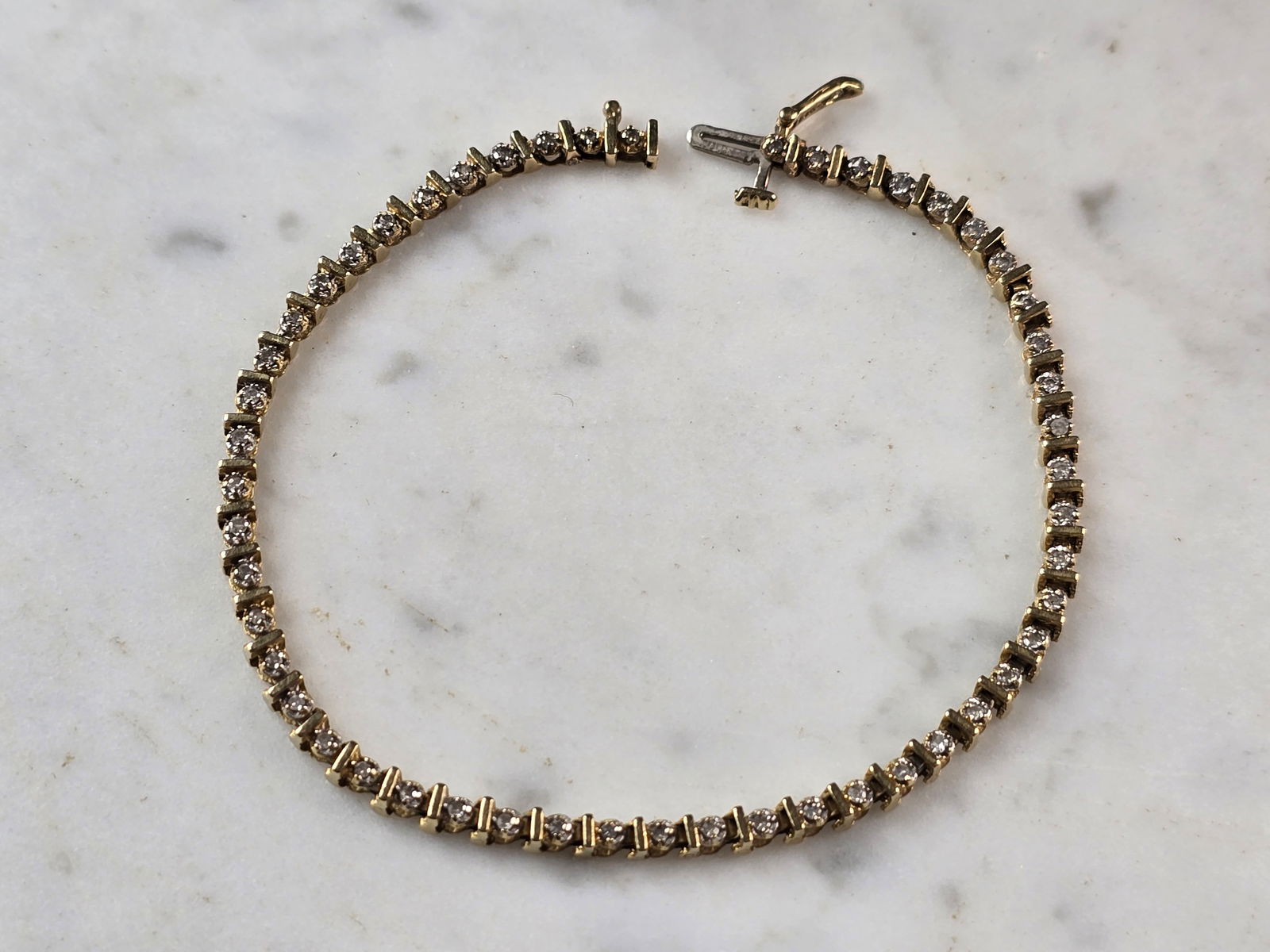 Womens Vintage Estate 14K Yellow Gold Diamond Tennis Bracelet: A WOMENS VINTAGE ESTATE 14K YELLOW GOLD DIAMOND TENNIS BRACELET. THE BRACELET MEASURES 7 3/4" LONG BY 1/8" WIDE, AND WEIGHS 7.2g. THERE ARE 50 TINY DIAMONDS IN THIS BRACELET. WOULD MAKE A GREAT GIFT F