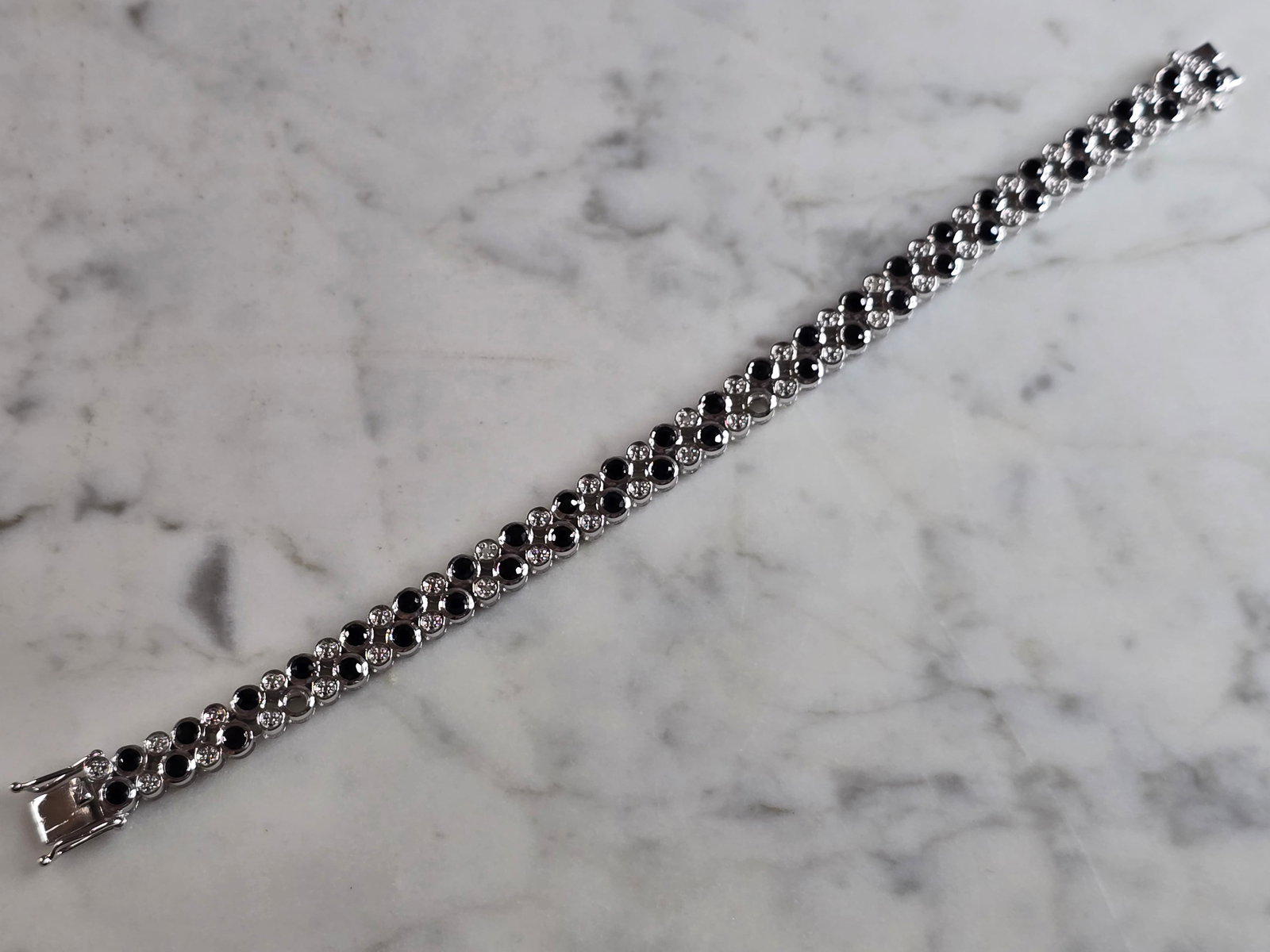 Womens Vintage Estate Sterling Silver Sapphire Bracelet: A WOMENS VINTAGE ESTATE STERLING SILVER TENNIS BRACELET WITH DARK SAPPHIRE COLORED STONES. THE BRACELET MEASURES 7 1/4" LONG BY 5/16" WIDE, AND WEIGHS 25.0g. NOT SURE IF STONES ARE NATURAL OR MAN MADE