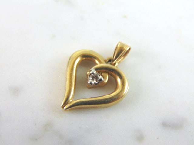 Womens Vintage Estate 10K Gold Diamond Heart Pendant: A WOMENS VINTAGE ESTATE 10K GOLD HEART DIAMOND PENDANT . PENDANT WEIGHS 1.8g, AND MEASURES 3/4" BY 1/2". THE DIAMOND IS ABOUT .05cts. WOULD MAKE A LOVELY GIFT FOR THAT SOMEONE SPECIAL. ANY OTHER QUEST