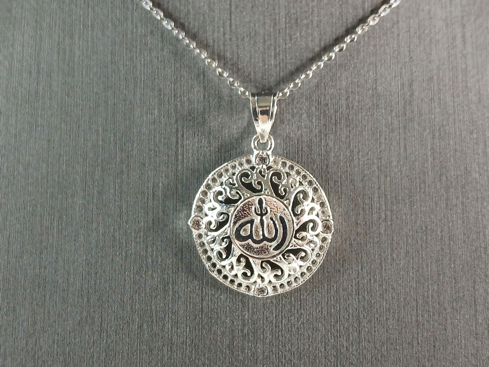 Sterling Silver CZ Religious Muslim Allah Pendant Necklace: A STERLING SILVER CZ MUSLIM ALLAH PENDANT WITH NECKLACE. THE PENDANT WITH NECKLACE WEIGHS 4.5g. THE PENDANT MEASURES 1" LONG BY 3/4" WIDE. THE NECKLACE MEASURES 18" LONG BUT IS ADJUSTABLE TO 16". MAKE
