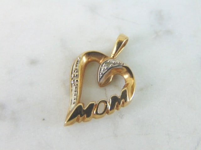 Womens Vintage Estate 10K Yellow Gold Mom Heart Pendant: A WOMENS VINTAGE ESTATE 10K YELLOW GOLD MOM HEART PENDANT. PENDANT WEIGHS 1.4g. THE PENDANT MEASURES 7/8" LONG BY 5/8" WIDE. THERE ARE TWO SMALL DIAMONDS IN THE PENDANT ABOUT .02cts OF DIAMONDS. MAKES