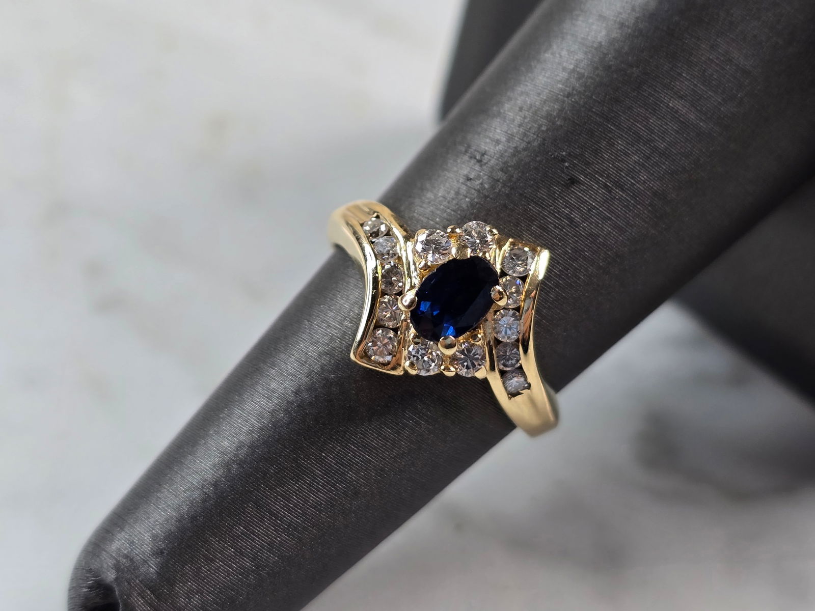 Womens Vintage Estate 14K Yellow Gold Sapphire & Diamond Ring: A WOMENS VINTAGE ESTATE 14K YELLOW GOLD RING WITH A BLUE SAPPHIRE STONE, ACCENTED WITH DIAMONDS. THE RING WEIGHS 3.7g, AND IS A SIZE 6.5. THE RING MEASURES 1/2" LONG. RING HAS 14 TINY DIAMONDS. ANY QU
