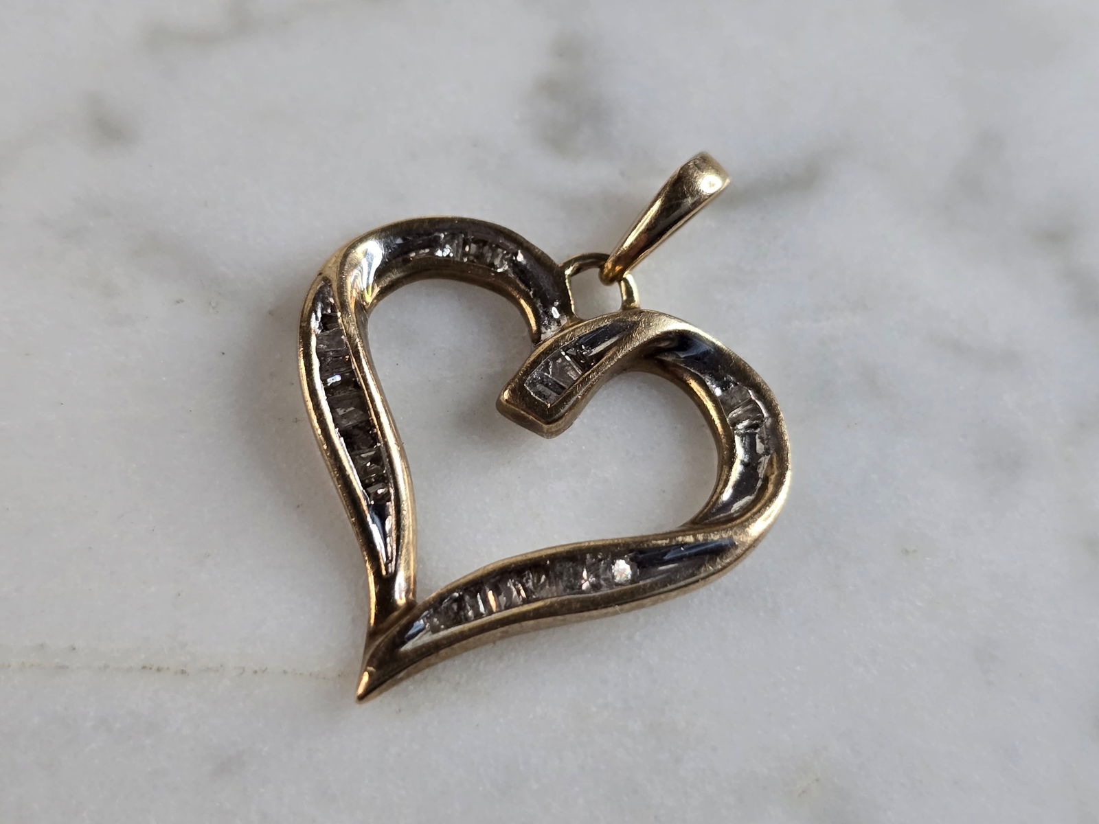 Womens Vintage Estate 10K Gold Diamond Heart Pendant: A WOMENS VINTAGE ESTATE 10K GOLD HEART DIAMOND PENDANT . PENDANT WEIGHS 1.4g, AND MEASURES 7/8" BY 3/4". THERE ARE ABOUT .20cts OF DIAMONDS IN THIS PENDANT. PENDANT IS MARKED ON THE BALE. WOULD MAKE A