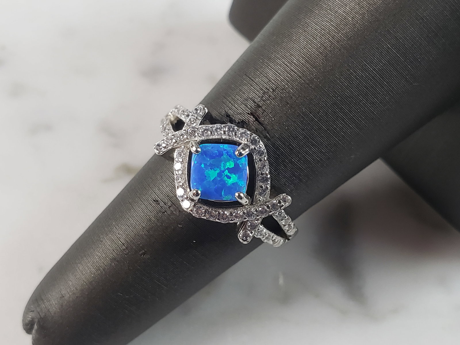 Womens Estate Sterling Silver Modernist Blue Opal & CZ Ring: A WOMENS ESTATE STERLING SILVER MODERNIST BLUE OPAL COLORED RING. THE RING IS A SIZE 6.0 AND WEIGHS 3.2g. WIDTH OF RING MEASURES 3/8". NOT SURE IF STONE IS NATURAL OR MAN MADE. THE RING MAKES A BEAUTI