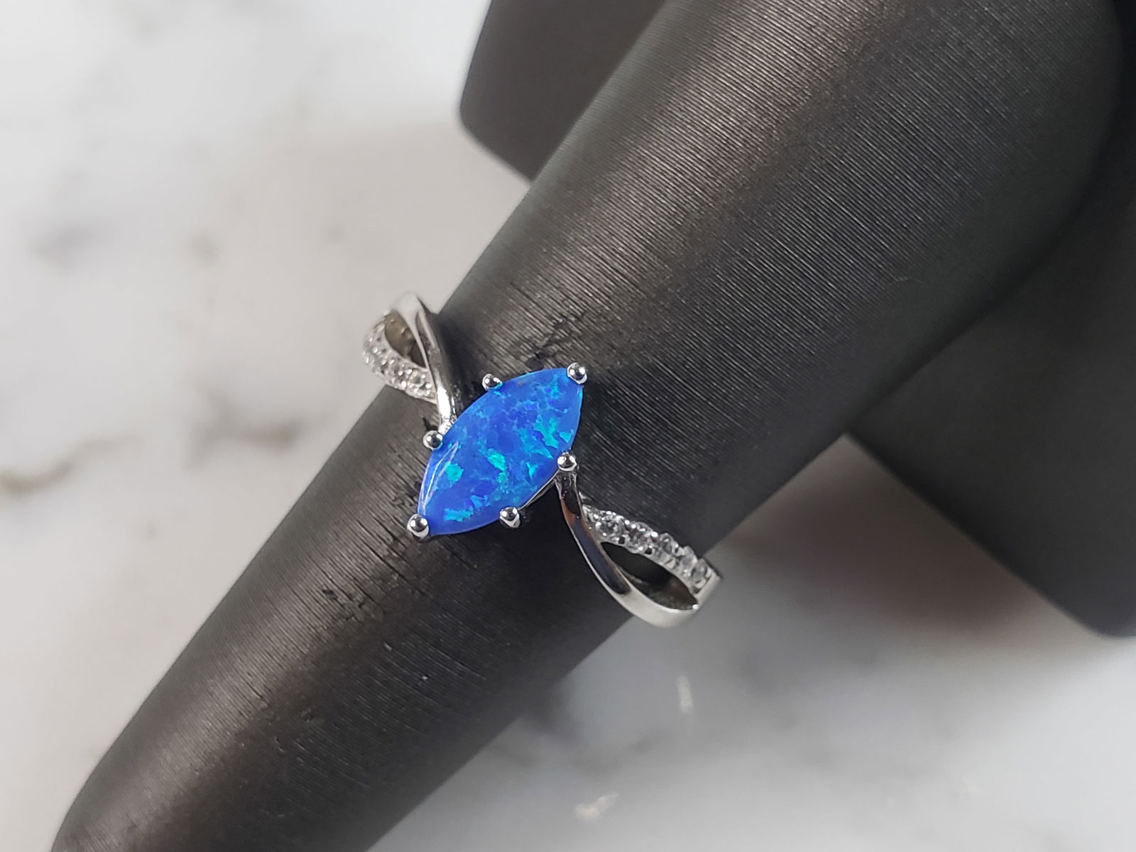 Womens Estate Sterling Silver Modernist Blue Opal & CZ Ring: A WOMENS ESTATE STERLING SILVER MODERNIST BLUE OPAL COLORED RING. THE RING IS A SIZE 8.25 AND WEIGHS 2.6g. WIDTH OF RING MEASURES 3/8". NOT SURE IF STONE IS NATURAL OR MAN MADE. THE RING MAKES A BEAUT