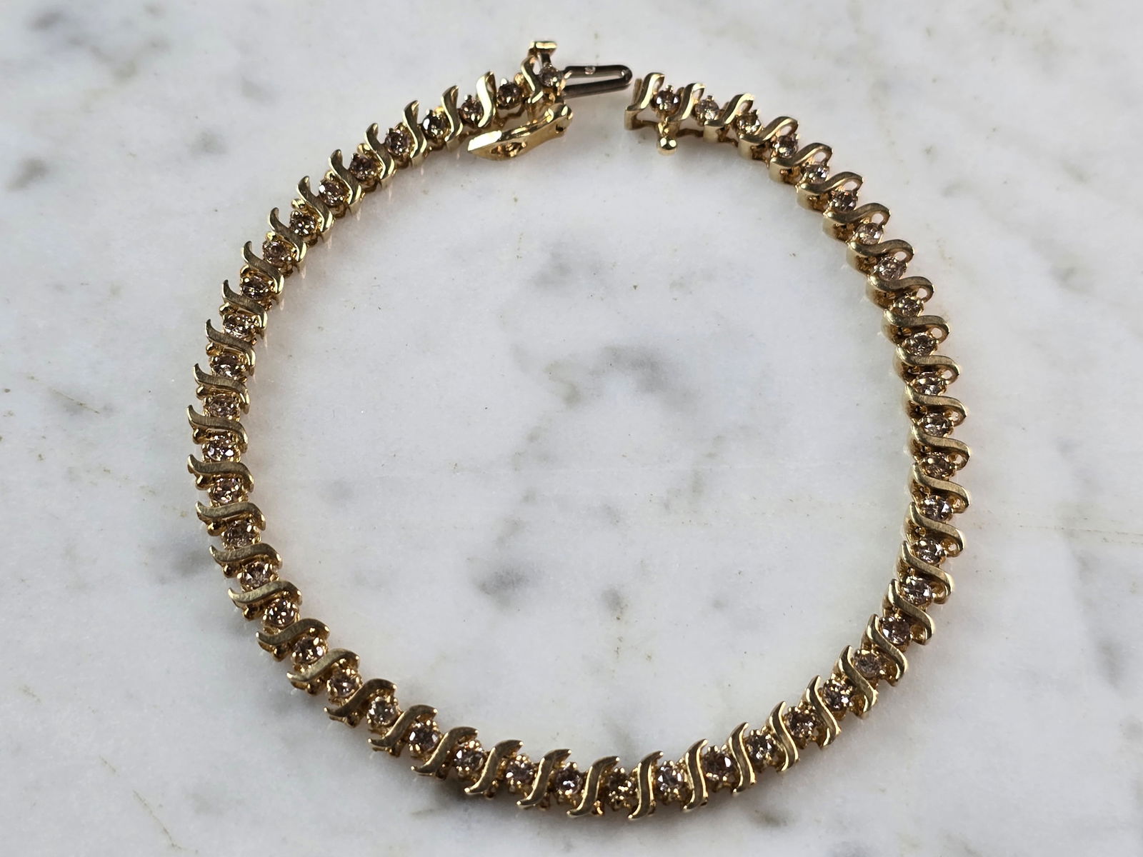 Womens Vintage Estate 10K Gold Diamond Tennis Bracelet: A WOMENS VINTAGE ESTATE 10K WOMENS TENNIS BRACELET. THE BRACELET MEASURES 7 1/2" LONG BY 3/16" WIDE, AND WEIGHS 8.3g. THERE ARE 48 SMALL DIAMONDS. WOULD MAKE A GREAT GIFT FOR THAT SPECIAL SOMEONE. ANY
