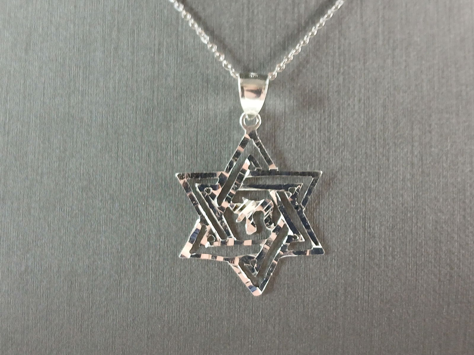 Sterling Silver Jewish Judaica Star of David Chai Pendant Necklace: A STERLING SILVER STAR OF DAVID CHAI PENDANT WITH NECKLACE. THE PENDANT WITH NECKLACE WEIGHS 3.1g. THE NECKLACE MEASURES 18" LONG, AND IS ADJUSTABLE TO 16" LONG. THE PENDANT MEASURES 1 1/2" LONG BY 1"