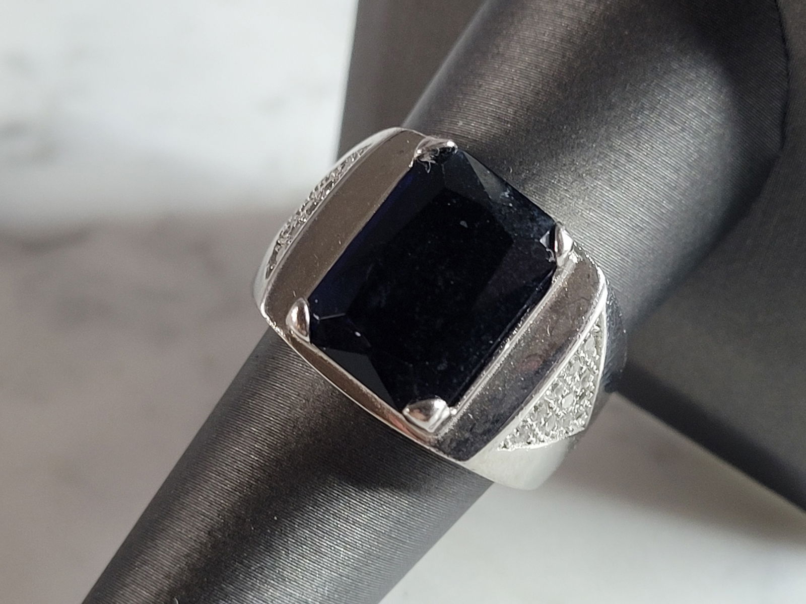 Mens Estate Sterling Silver Modernist Sapphire Ring: A MENS ESTATE STERLING SILVER MODERNIST RING. THE RING IS A SIZE 8.75 AND WEIGHS 11.8g. STONE IS A SAPPHIRE COLORED GLASS. RING MEASURES ABOUT 5/8" LONG. RING IS MARKED 925 ON THE INSIDE OF THE BAND.