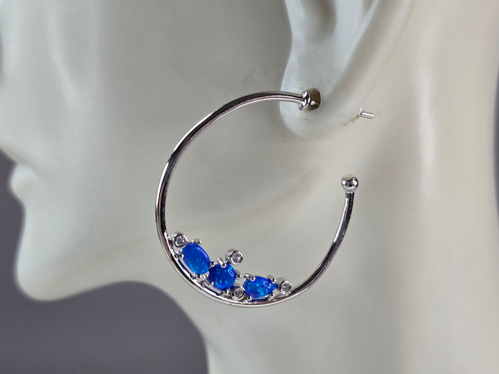Womens Sterling Silver Modernist Blue Opal Hoop Earrings: A PAIR OF WOMENS STERLING SILVER BLUE OPAL COLORED EARRINGS THAT WEIGH 4.0g AND MEASURES 1 1/4" LONG BY 1/16" WIDE. NOT SURE IF STONES ARE NATURAL OR MAN MADE. ANY QUESTIONS, PLEASE DO NOT HESITATE TO