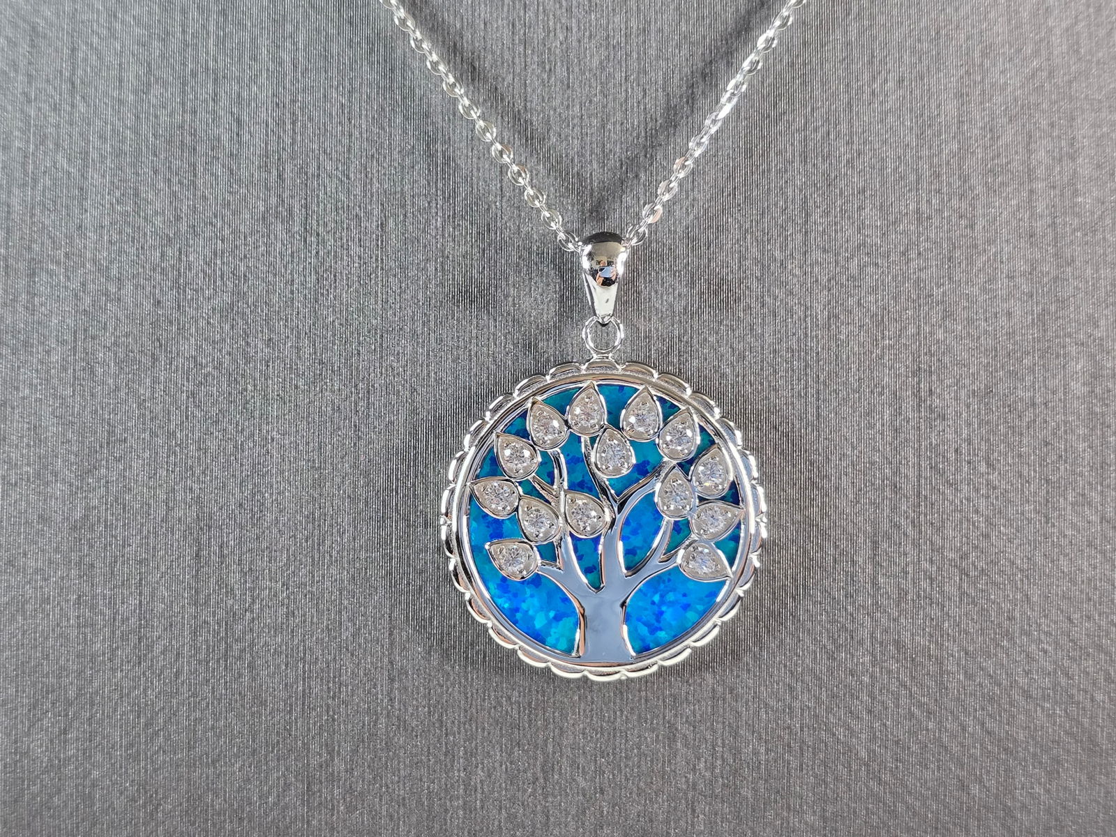 Womens Sterling Silver Blue Opal Tree of Life Pendant Necklace: A WOMENS ESTATE STERLING SILVER BLUE OPAL TREE OF LIFE PENDANT WITH NECKLACE. THE PENDANT WITH THE NECKLACE WEIGHS 7.4g. PENDANT MEASURES 1 1/4" LONG BY 7/8" WIDE. THE NECKLACE MEASURES 18" LONG, AND