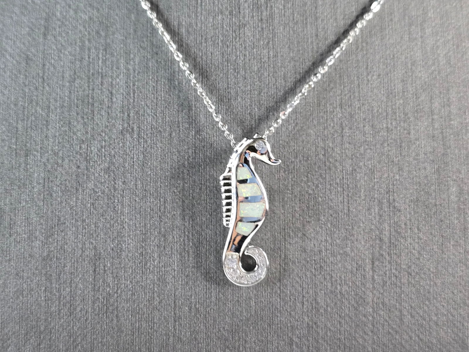Womens Sterling Silver Opal Seahorse Pendant Necklace: A WOMENS STERLING SILVER OPAL SEAHORSE PENDANT. THE PENDANT WITH NECKLACE WEIGHS 4.4g. THE PENDANT MEASURES 1" LONG BY 3/8" WIDE. THE NECKLACE MEASURES 18" LONG AND IS ADJUSTABLE TO 16" LONG. NOT SURE