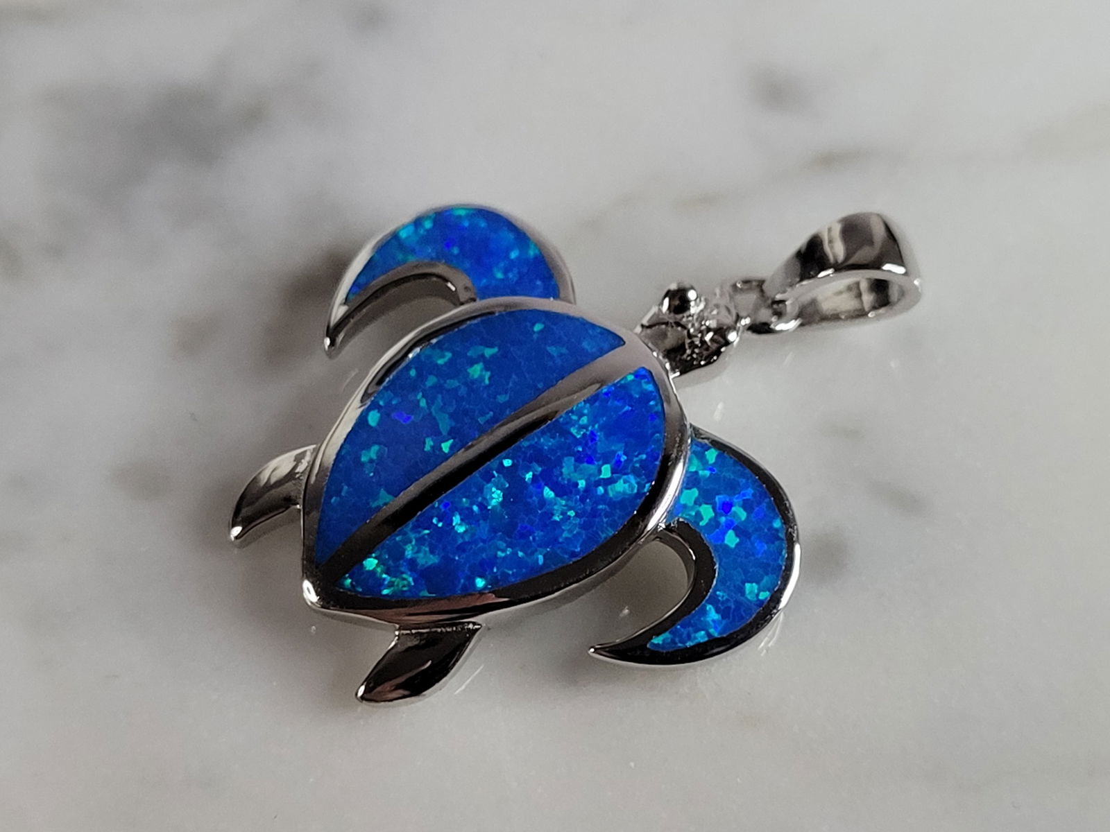 Womens Sterling Silver Blue Opal Sea Turtle Pendant: A WOMENS STERLING SILVER BLUE OPAL SEA TURTLE PENDANT. NOT SURE IF STONES ARE REAL OR MAN MADE. THE PENDANT WEIGHS 3.4g AND MEASURES 1 1/8" LONG BY 7/8" WIDE. MAKES A GREAT GIFT FOR THAT SOMEONE SPECI