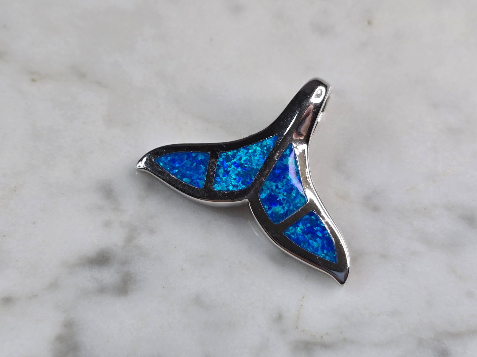 Womens Sterling Silver Blue Opal Modernist Whale Pendant: A WOMENS STERLING SILVER BLUE OPAL MODERNIST WHALE PENDANT. NOT SURE IF STONES ARE NATURAL OR MAN MADE. THE PENDANT WEIGHS 6.1g AND MEASURES 1 1/4" LONG BY 7/8" WIDE. MAKES A GREAT GIFT FOR THAT SOMEO