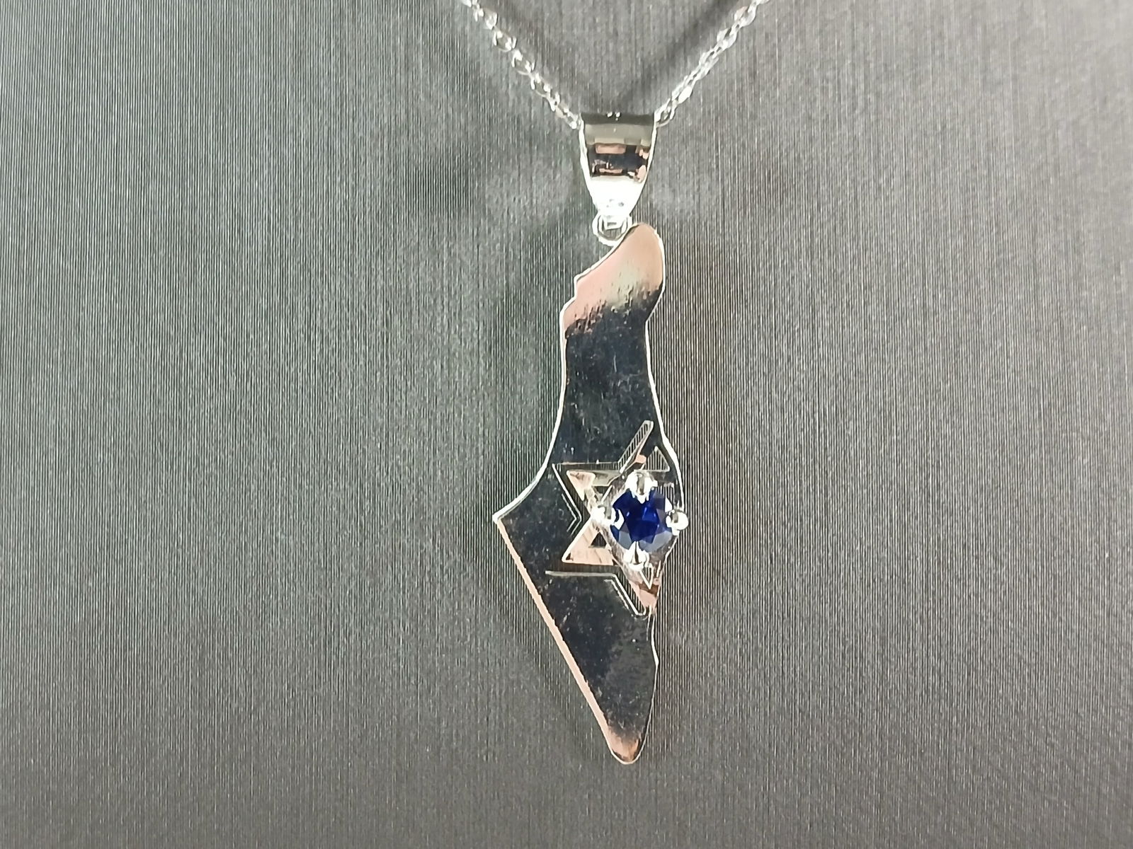 Sterling Silver Jewish Judaica Star of David Israel Pendant Necklace: A STERLING SILVER JUDAICA STAR OF DAVID PENDANT IN THE SHAPE OF ISRAEL. THE PENDANT WITH NECKLACE WEIGHS 3.4g. THE NECKLACE MEASURES 18" LONG AND IS ADJUSTABLE TO 16" LONG. THE PENDANT MEASURES 1 3/4"