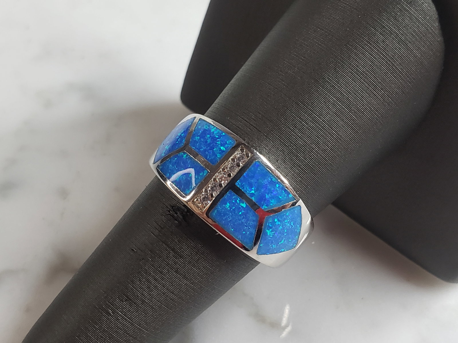 Womens Estate Sterling Silver Modernist Blue Opal Ring: A WOMENS ESTATE STERLING SILVER MODERNIST BLUE OPAL COLORED RING. THE RING IS A SIZE 8.0 AND WEIGHS 6.5g. WIDTH OF RING MEASURES 3/8". NOT SURE IF STONE IS NATURAL OR MAN MADE. THE RING MAKES A BEAUTI