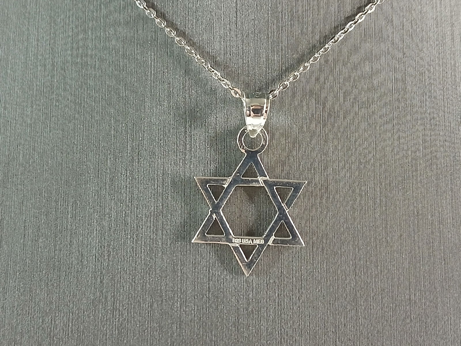 Sterling Silver Jewish Judaica Star of David Pendant Necklace: A STERLING SILVER STAR OF DAVID PENDANT WITH NECKLACE. THE PENDANT WITH NECKLACE WEIGHS 3.0g. THE NECKLACE MEASURES 18" LONG, AND IS ADJUSTABLE TO 16" LONG. THE PENDANT MEASURES 1" LONG BY 3/4" WIDE.
