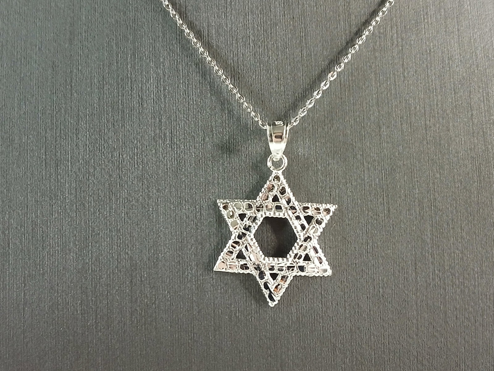Sterling Silver Jewish Judaica Star of David Pendant Necklace: A STERLING SILVER STAR OF DAVID PENDANT WITH NECKLACE. THE PENDANT WITH NECKLACE WEIGHS 2.7g. THE NECKLACE MEASURES 18" LONG, AND IS ADJUSTABLE TO 16" LONG. THE PENDANT MEASURES 1 1/4" LONG BY 3/4" WI