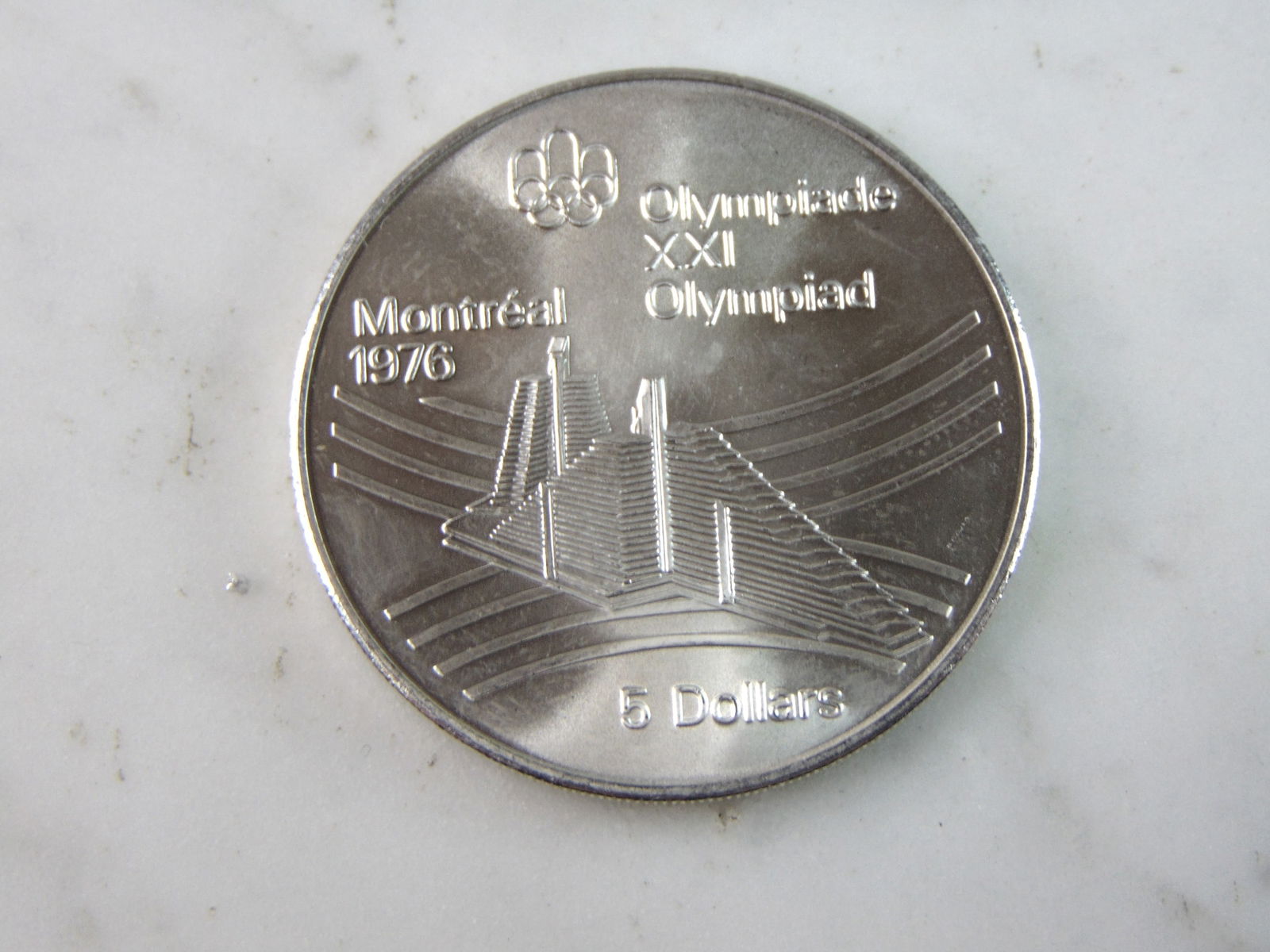 1976 $5 Canadian '76 Montreal Summer Olympics Silver Coin: FOR SALE IS THIS 1976 $5 CANADIAN '76 MONTREAL SUMMER OLYMPICS SILVER COIN. COIN APPEARS TO BE IN VERY GOOD CONDITION, UNC , HOWEVER WE ARE NOT COIN EXPERTS WHEN IT COMES TO PROPER GRADING. PICTURES