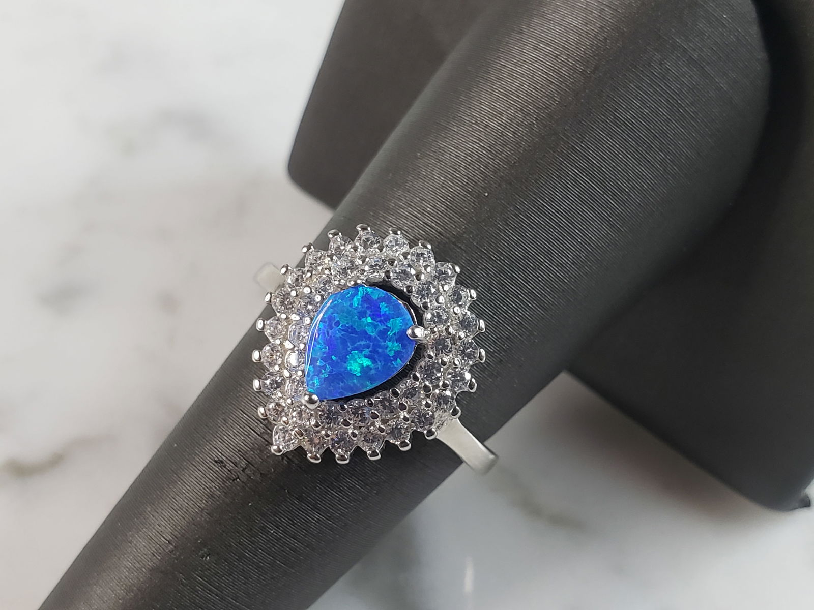 Womens Estate Sterling Silver Modernist Blue Opal & CZ Ring: A WOMENS ESTATE STERLING SILVER MODERNIST BLUE OPAL COLORED RING. THE RING IS A SIZE 7.25 AND WEIGHS 4.0g. WIDTH OF RING MEASURES 5/8". NOT SURE IF STONE IS NATURAL OR MAN MADE. THE RING MAKES A BEAUT