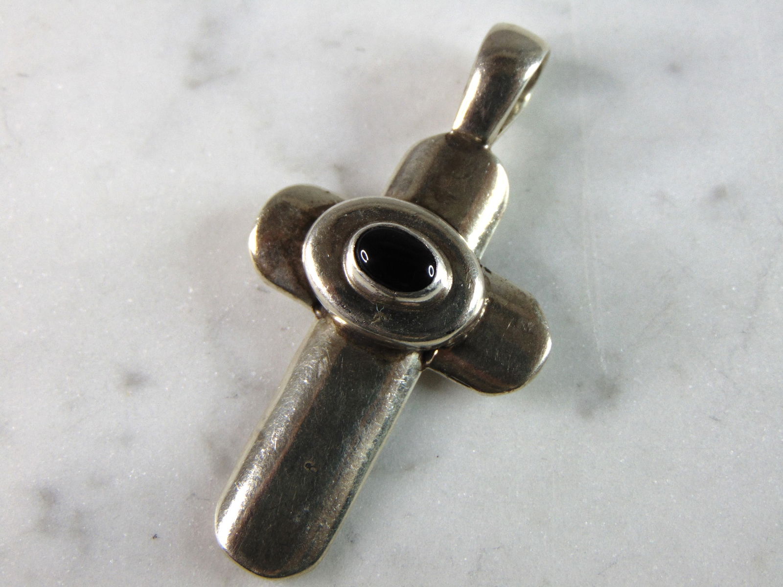 Womens Vintage Estate Sterling Silver Onyx Cross Pendant: A WOMENS VINTAGE ESTATE .925 STERLING SILVER ONYX CROSS PENDANT. THE PENDANT WEIGHS 12.1g. NOT SURE IF STONE IS NATURAL OR MAN MADE. THE PENDANT MEASURES 2" LONG BY 1" WIDE. THIS WOULD MAKE A NICE GIF