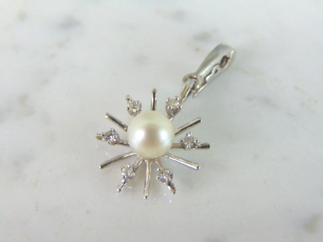 Womens 14k White Gold Diamond Pearl Snowflake Pendant: A WOMENS VINTAGE ESTATE 14K WHITE GOLD DIAMOND AND PEARL SNOWFLAKE PENDANT. NOT SURE IF THE PEARL IS REAL OR MAN MADE. THERE ARE ABOUT .18cts OF DIAMONDS. THE TOTAL WEIGHT IS 3.0g. THE PENDANT MEASURE