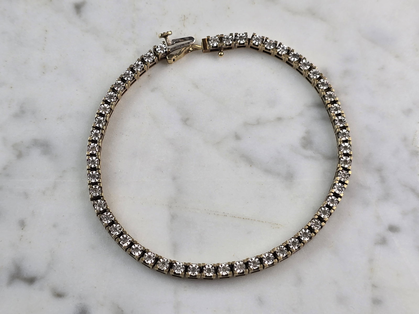 Womens Vintage Estate 10k Gold Diamond Tennis Bracelet: A WOMENS VINTAGE ESTATE 10K WOMENS TENNIS BRACELET WITH ABOUT 0.51cts WORTH OF DIAMONDS. THE BRACELET MEASURES 7 1/2" LONG BY 1/8" WIDE AND WEIGHS 11.6g. WOULD MAKE A GREAT GIFT FOR THAT SPECIAL SOMEO