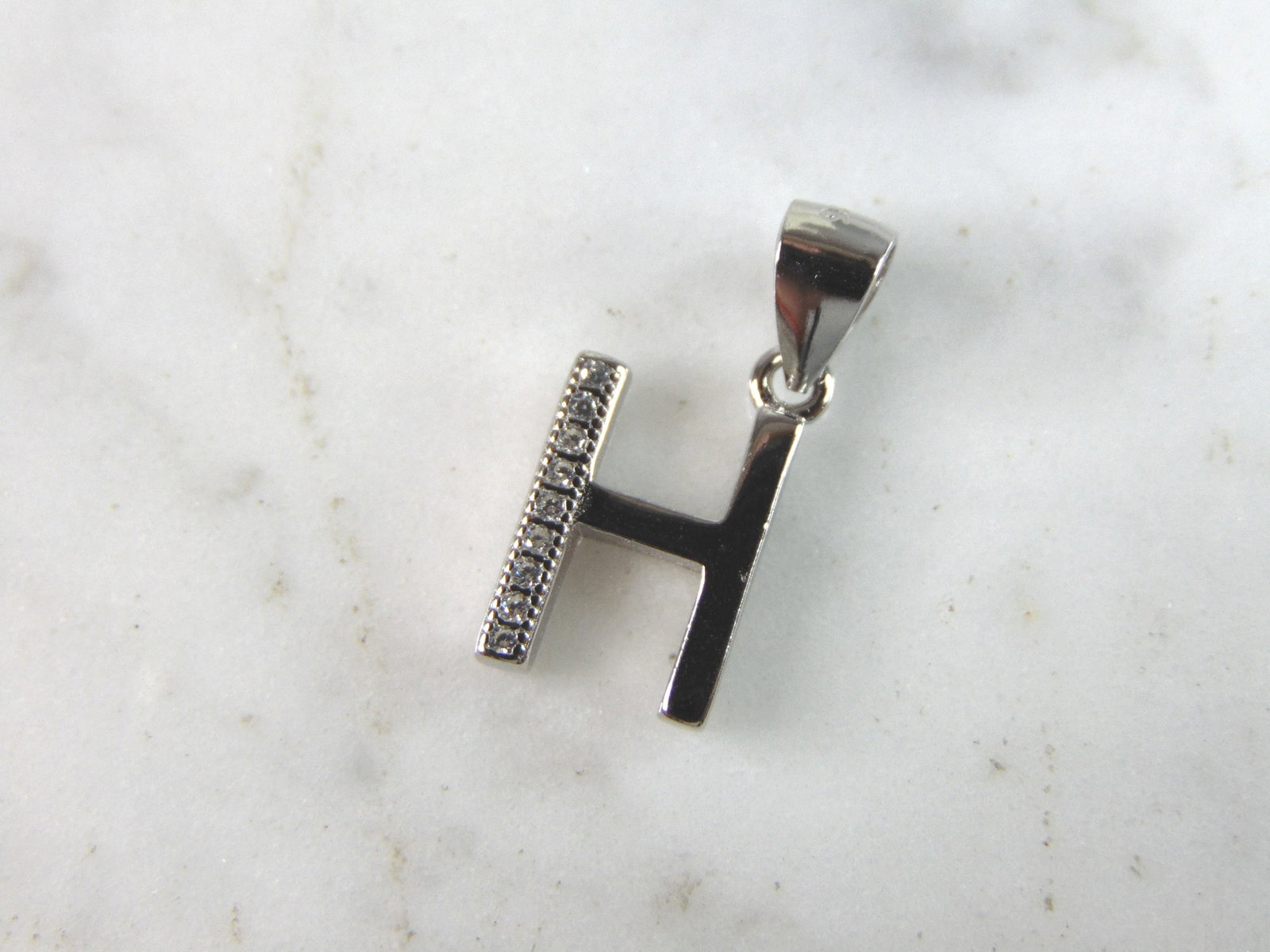 Womens Vintage Estate Sterling Silver CZ Letter "H" Pendant: FOR SALE IS THIS WOMENS VINTAGE ESTATE STERLING SILVER CZ LETTER "H" PENDANT. PENDANT WEIGHS 1.4g AND PENDANT MEASURES 3/4" LONG BY 3/8" WIDE. MAKES A GREAT GIFT FOR THAT SOMEONE SPECIAL. IF ANY QUEST