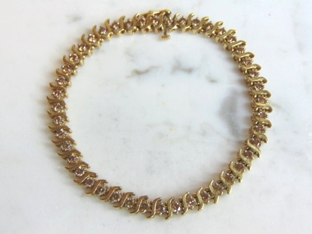 Womens Vintage 10K Gold Diamond Tennis Bracelet: A WOMENS VINTAGE ESTATE 10K WOMENS TENNIS BRACELET WITH ABOUT 2.15cts OF DIAMONDS. THE BRACELET MEASURES 7 3/4" LONG BY 1/4" WIDE, AND WEIGHS 9.4g. WOULD MAKE A GREAT GIFT FOR THAT SPECIAL SOMEONE. AN